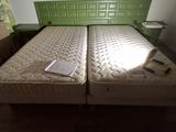 two twin beds in the room with a green headboard
