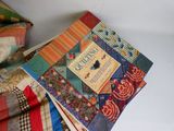 a pile of quilts on a table with a book on it