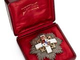 une image représentant une boîte rouge contenant une croix et une médaille