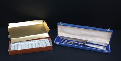 pair of silver plated spoons in a blue box on a black surface