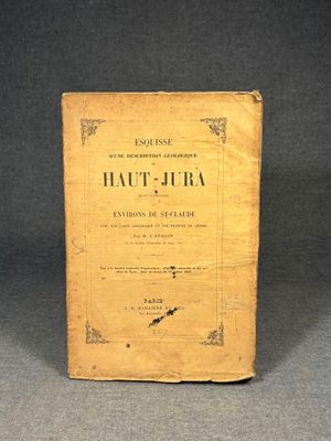 an old book sitting on top of a table next to a black background