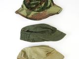 three hats are lined up on top of each other on a white surface