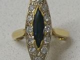 une image d'une bague en or avec une pierre bleue et des diamants