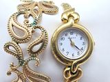 une montre-bracelet en or à laquelle est attachée une chaîne