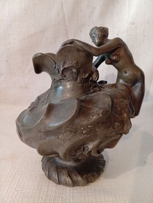 une statue en bronze représentant une femme et un oiseau sur un rocher