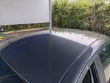 a car that is parked under a awning in the driveway