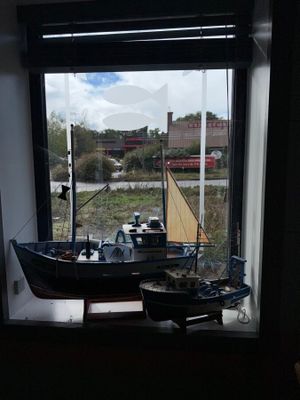 a small boat that is sitting in a window sill