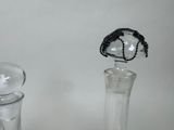 a glass bottle with a black lace top and a clear glass bottle with a black lace top and a clear glass bottle with a black lace top