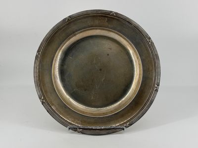 an antique silver plate on a stand on a white background
