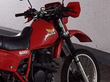 a red motorcycle that is parked in a garage