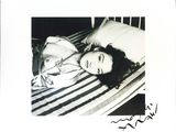 a black and white photo of a woman laying on a bed