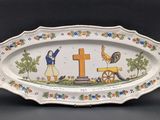 an oval platter with a picture of a woman and a cross on it