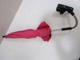 a pink umbrella with a black handle on a white table