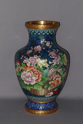a blue vase with flowers on it sitting on a table