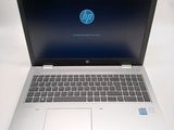 hp laptop computer sitting on a white surface with a blue screen