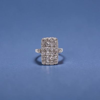 un gros plan d'une bague en diamant posée sur une surface bleue