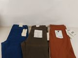 three pairs of men ' s pants sitting on a table