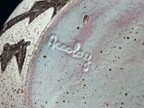 a close up of a vase with a bird design on it