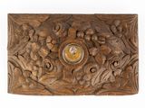 boîte en bois sculpté avec une horloge au centre