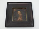 painting of a woman in a black frame on a white wall