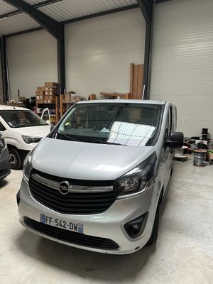 une camionnette argentée garée dans un garage à côté d'autres voitures