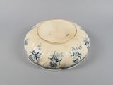 a blue and white bowl with a flower design on it