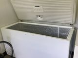 a white chest freezer sitting next to a bicycle in a room