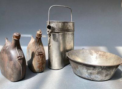 trois vases, un bol et une bouteille posés sur une table