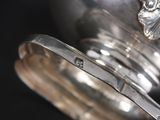 a close up of a silver plate with a spoon in it