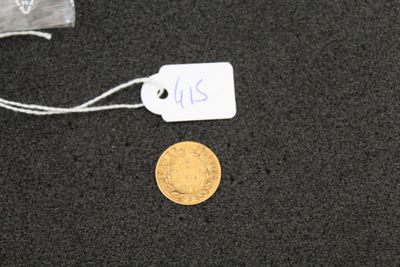 a gold coin on a black surface with a price tag