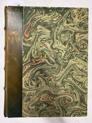 un vieux livre orné d'un motif marbré, posé sur une table