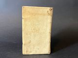 an old book sitting on top of a table next to a black background