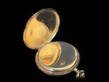an image of a gold pocket watch with a black background