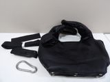 black leather handbag with zippers and a carabine on a white surface