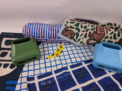 a blue and white towel, a blue and green case, and a blue and white towel on a blue and white checkered blanket