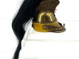 a gold helmet with a red feather on top of it
