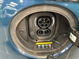 a close up of a blue car with an electric charger plugged into it