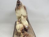 a figurine of a cat sitting on top of a wooden block