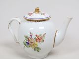 une théière blanche ornée d'un motif floral