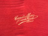 the back of a red shirt with a gold logo on it