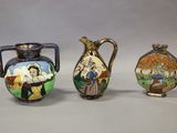 trois vases ornés de portraits, posés sur une table