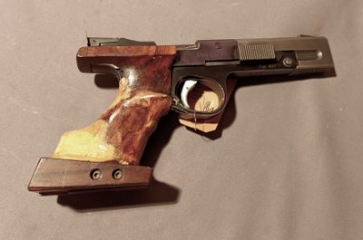 a gun that is on a table with a piece of wood