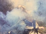 a woman laying on the ground with smoke coming out of her mouth