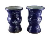 deux vases bleus ornés de fleurs sur fond blanc