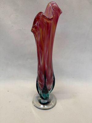 un vase en verre posé sur un socle, sur une table