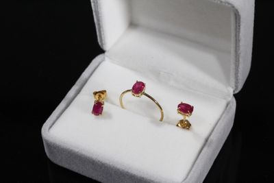 une photo représentant une paire de boucles d'oreilles dans un écrin posé sur une surface noire