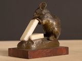 a statue of a mouse with a piece of cheese in it ' s mouth