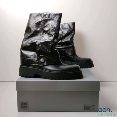 une paire de bottes noires posée sur une boîte