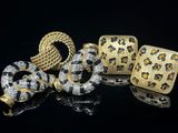 un gros plan sur deux bijoux en or et en diamants posés sur une surface noire