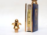 a small bottle of perfume next to a small book